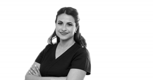 A nurse smiling wearing scrubs.